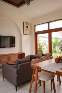 a living room with a couch and a table at Selena Home Tropical Villa Jimbaran in Jimbaran