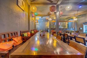 a large wooden table in a restaurant with chairs at Siem Reap Pub Hostel in Siem Reap