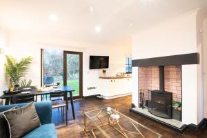 a living room with a fireplace and a table at Northern Hideaways Apple Store, Ellingham in Chathill