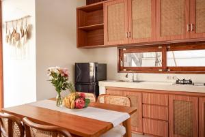 a kitchen with a table with a vase of flowers on it at Selena Home Tropical Villa Jimbaran in Jimbaran