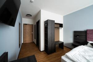 a bedroom with a bed and a wooden door at PEN Smart Hotel in Türkheim