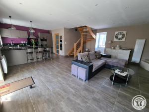 a living room with a couch and a kitchen at Le chapelou in Égletons