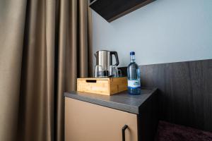 a bottle of alcohol sitting on a table in a room at PEN Smart Hotel in Türkheim