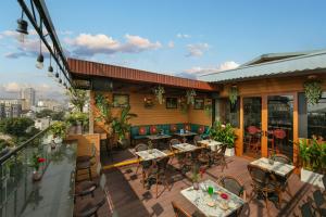 ein Restaurant mit Tischen und Stühlen auf einer Terrasse in der Unterkunft Hanoi Pearl Hotel in Hanoi