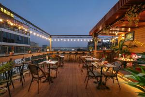 eine Außenterrasse mit Tischen, Stühlen und Lampen in der Unterkunft Hanoi Pearl Hotel in Hanoi