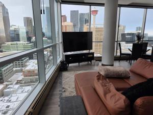 a living room with a couch and a flat screen tv at Breath-Taking-View-5 Guest DTskyline 18th Floor in Calgary