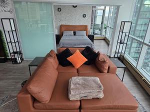 a brown couch with pillows and a bed in a room at Breath-Taking-View-5 Guest DTskyline 18th Floor in Calgary