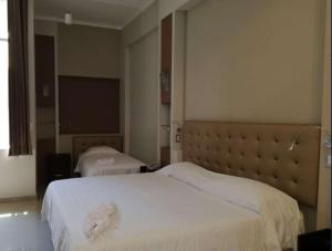 een hotelkamer met twee bedden en een flatscreen-tv bij Hotel Cerro Azul in La Merced