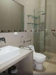 een badkamer met een toilet, een wastafel en een douche bij Hotel Cerro Azul in La Merced