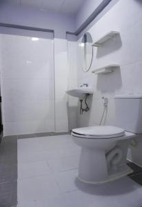 a white bathroom with a toilet and a sink at Nan Lanna Hotel in Nan