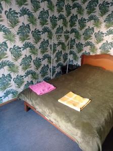a bedroom with a bed with a green and white wallpaper at Backpackers Georgia in Tbilisi City