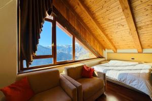 a bedroom with a bed and a couch and a window at Residence Cianfuran in Bardonecchia
