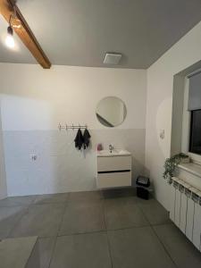 ein Badezimmer mit Waschbecken und Spiegel an der Wand in der Unterkunft Riverside Stay at Stary Rynek - billiards, foosball and arcade games in Goniądz + 85 Fotos