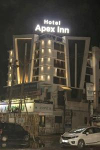 a hotel apx inn with cars parked in front of it at Hotel Apex Inn in Vapi