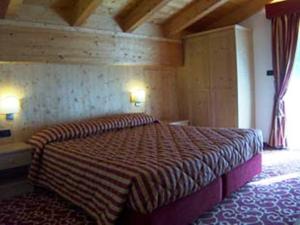 ポッツァ・ディ・ファッサにあるResidence Club La Betullaのベッドルーム1室(大型ベッド1台付)