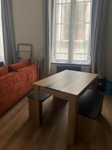 un salon avec une table en bois et un canapé dans l'établissement le Limo: logement cosy en hyper centre, à Périgueux