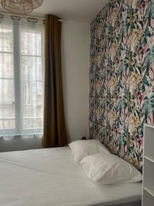 une chambre avec un lit avec une tête de lit fleurie dans l'établissement le Limo: logement cosy en hyper centre, à Périgueux