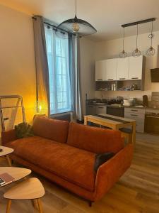 un salon avec un canapé et une cuisine dans l'établissement le Limo: logement cosy en hyper centre, à Périgueux