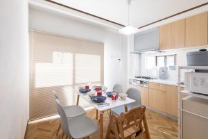a kitchen with a white table and chairs and a table and chairsktop at Kotori Ayase in Tokyo