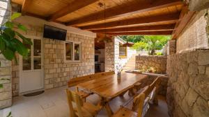 una sala da pranzo all'aperto con tavolo e sedie in legno di Villa None Kate by Villas Guide a Dubrovnik