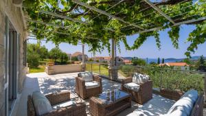 patio con tavolo e sedie in vimini di Villa None Kate by Villas Guide a Dubrovnik
