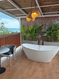 een badkamer met een bad, een tafel en een stoel bij Tantawan sea view residence 山海居 in Salad Beach