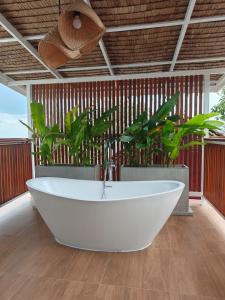 een wit bad in een kamer met planten bij Tantawan sea view residence 山海居 in Salad Beach