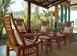 een groep stoelen op een veranda bij Forest & Fields Sinharaja in Deniyaya