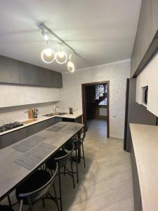 una cucina con tavolo e alcune sedie di ViLLA KUMANETS a Skhidnytsia