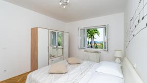 una camera da letto bianca con un letto e due finestre di Villa None Kate by Villas Guide a Dubrovnik Altre 25 foto