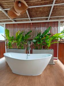 een wit bad in een kamer met planten bij Tantawan sea view residence 山海居 in Salad Beach