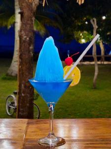 a blue drink in a martini glass on a table at BAIBAI Long Beach in New Agutaya