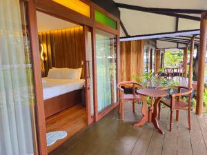 a room with a bed and a table and chairs at BAIBAI Long Beach in New Agutaya