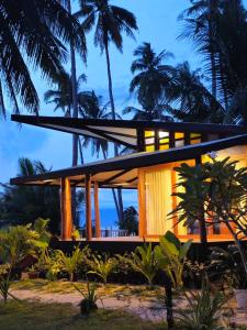 a house on the beach at night with palm trees at BAIBAI Long Beach in New Agutaya +6 photos