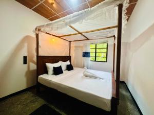 a bedroom with a canopy bed with white sheets and pillows at Sea Paradise Hidden Villa in Tangalle
