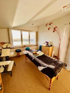 Cette chambre comprend un lit, un bureau et des chaises. dans l'établissement "La Bounty" gite 50m de la plage avec spa, à Barneville-Carteret