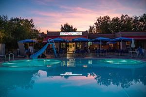 ein Schwimmbad mit Rutsche vor einem Restaurant in der Unterkunft Camping Village Torre Pendente in Pisa
