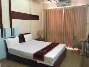 a bedroom with a large bed and a window at Sunrise Hotel in Hanoi