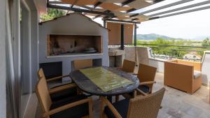 a balcony with a table and chairs and a fireplace at House Vidovic by Villas Guide in Mlinište