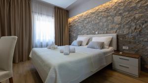 a bedroom with a bed and a stone wall at House Vidovic by Villas Guide in Mlinište