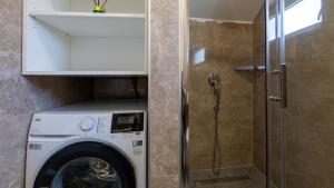 a washing machine in a bathroom with a shower at House Vidovic by Villas Guide in Mlinište
