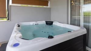 a bath tub filled with blue water in a bathroom at House Vidovic by Villas Guide in Mlinište +14 photos