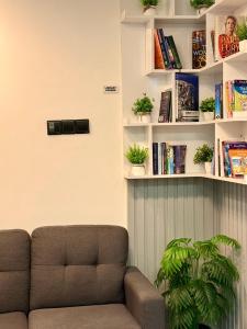 a living room with a couch and shelves with books at Reinforce Residence in Thulusdhoo +29 photos