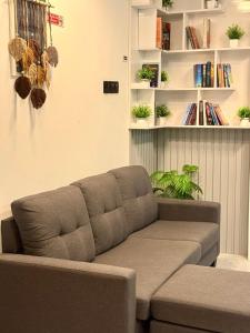 a brown couch in a living room with a book shelf at Reinforce Residence in Thulusdhoo