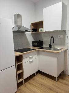 eine Küche mit weißen Schränken, einer Spüle und einer Theke in der Unterkunft Alojamiento Baeza-El Limonero B in Baeza