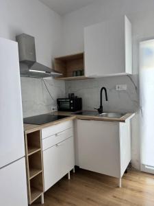 a kitchen with white cabinets and a sink and a refrigerator at Alojamiento Baeza- El Limonero A in Baeza +24 photos