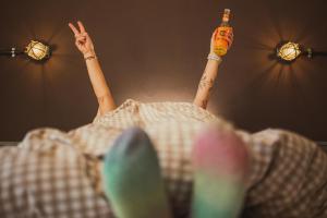iemand die in bed ligt met een fles bier bij Harz BnB Werkmeister in Sankt Andreasberg