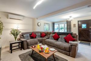 ein Wohnzimmer mit einem braunen Sofa und roten Kissen in der Unterkunft 1 Bed in Pluckley oc-a29239 in Smarden