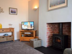 a living room with a fireplace and a television at 1 Bed in Seahouses oc-cn123 in Seahouses