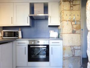 a kitchen with white cabinets and an oven at 1 Bed in Seahouses oc-cn123 in Seahouses